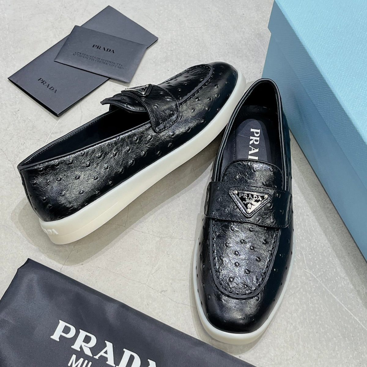 Ostrich Grain Metal Triangle Badge Slip-On Loafers S283422