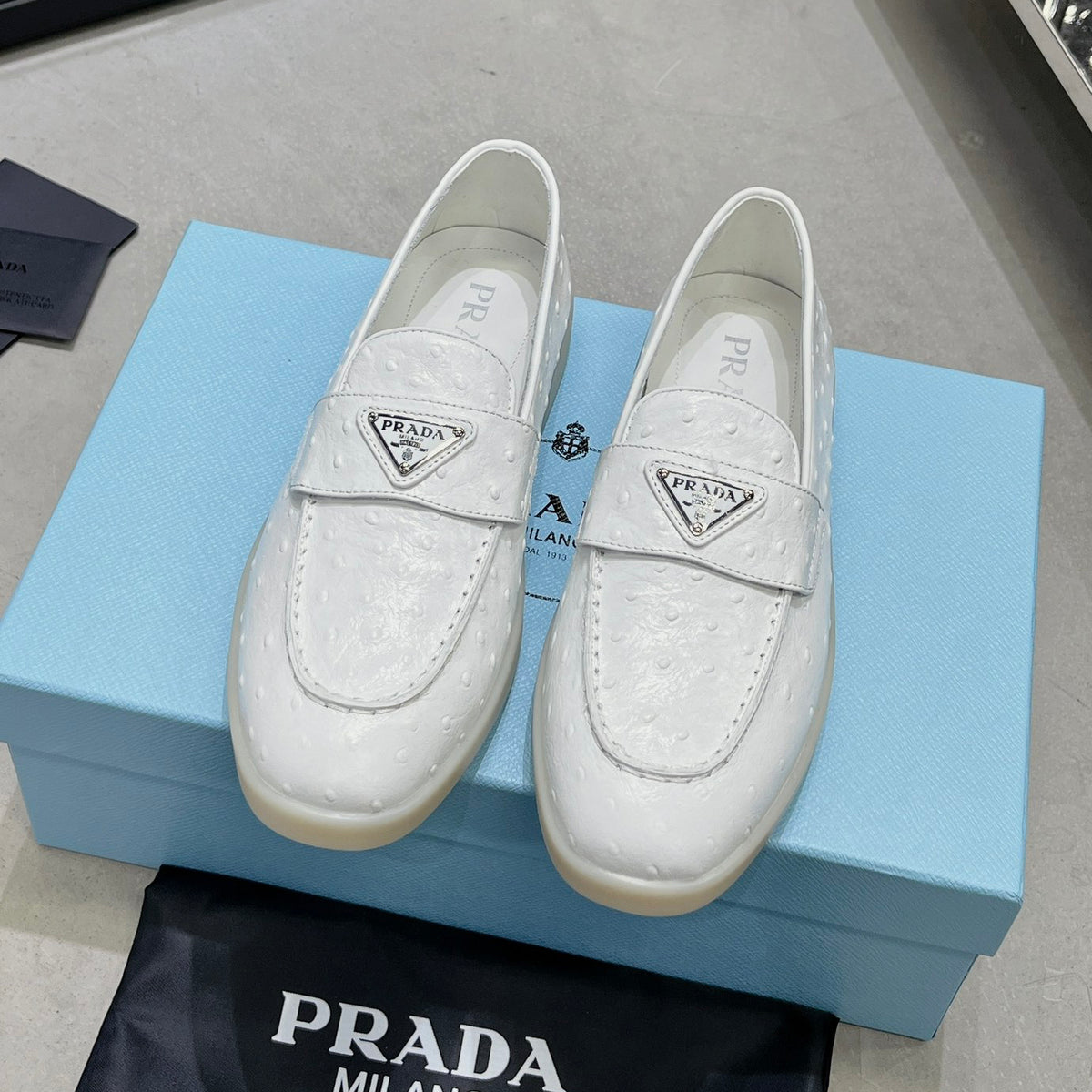 Ostrich Grain Metal Triangle Badge Slip-On Loafers S283422